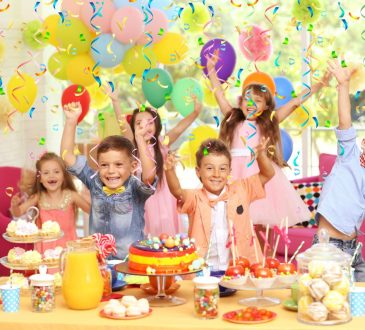 A little boy is enjoying his birthday party with his great school friends, eating deliciou ...