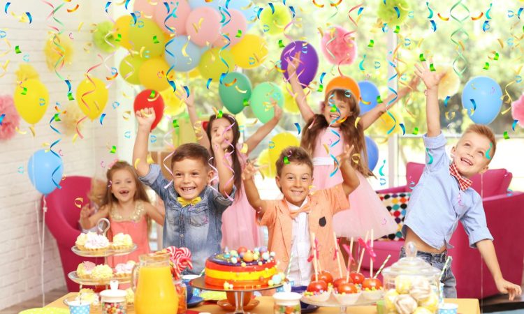 A little boy is enjoying his birthday party with his great school friends, eating deliciou ...